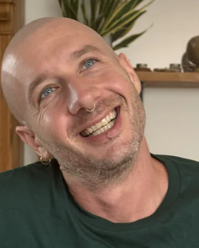 Fabrizio smiling at home, head tilted, in a green t-shirt